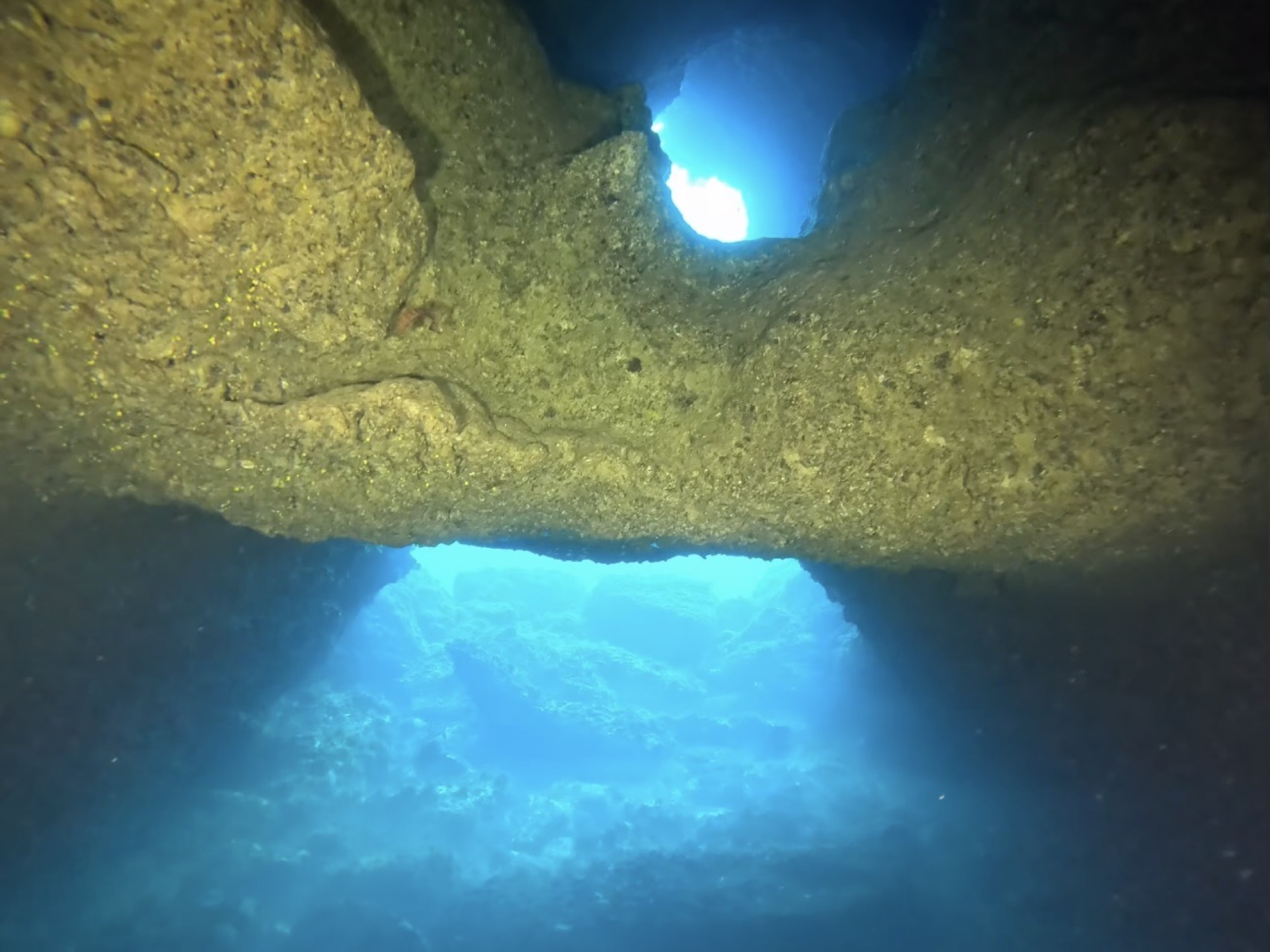 Sunlight spilling through an underwater cave opening in Mallorca